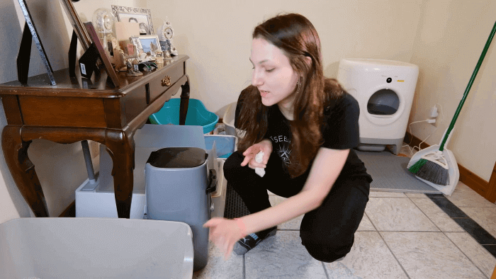 Persona limpiando el arenero del gato